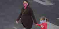 pregnant woman and child walk with masks during covid outbreak x