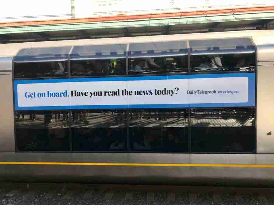 Photo of train with NewsCorp Australia wrap ad. Text reads, "Get on board. Have you read the news today?"